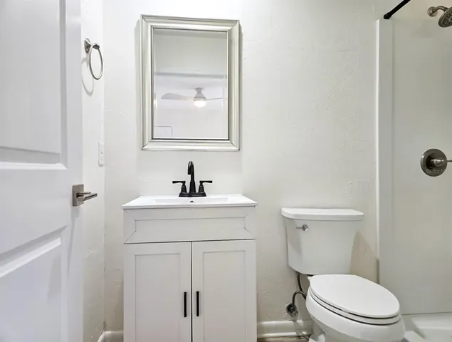 a white toilet sitting next to a shower