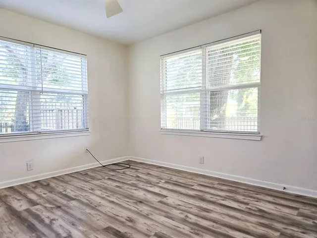 a view of empty room with wooden floor