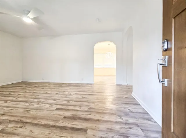 a view of empty room with wooden floor
