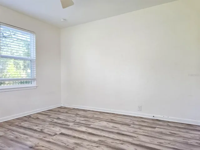 a view of a room with wooden floor and a window