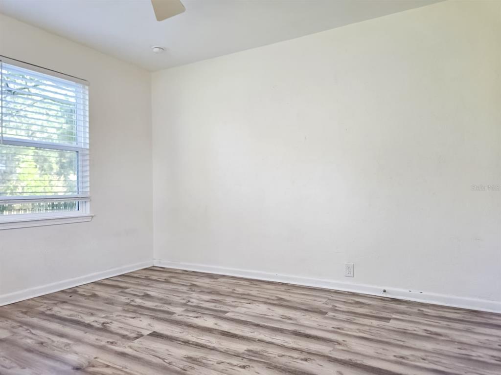 518 Northwest 27th Avenue Gainesville, FL 32609 - Photo 31 of 34 an empty room with wooden floor and windows