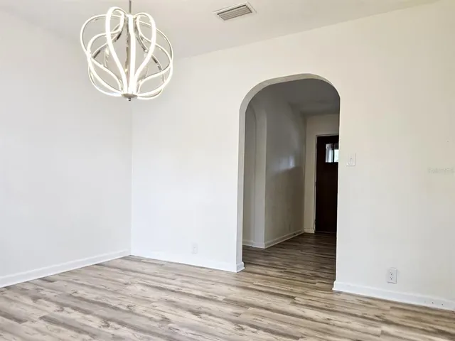 a view of empty room with wooden floor and cabinets