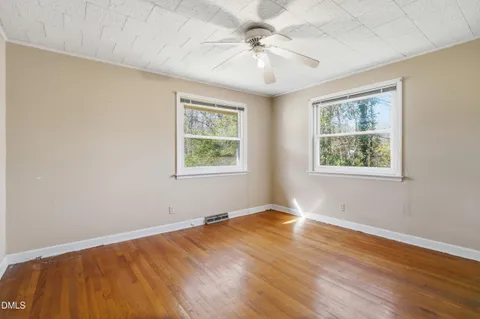 a view of an empty room with a window and a ceiling fan