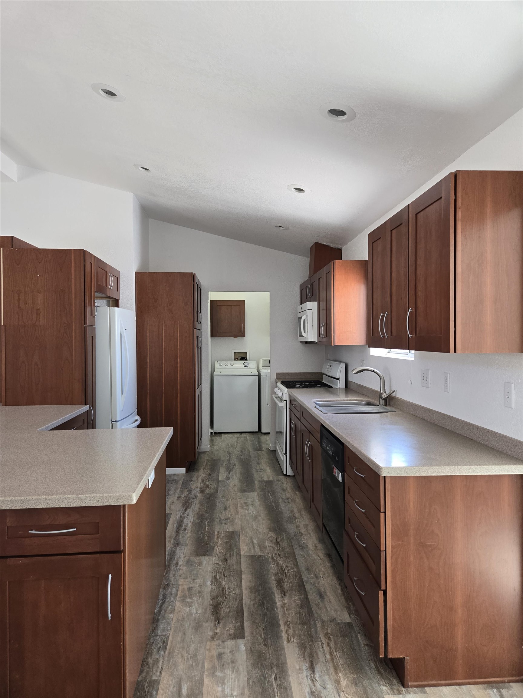 75 Sequoia Street Chalfant, CA 93514 - Photo 4 of 21 a large kitchen with stainless steel appliances a large counter top a stove a sink and a refrigerator
