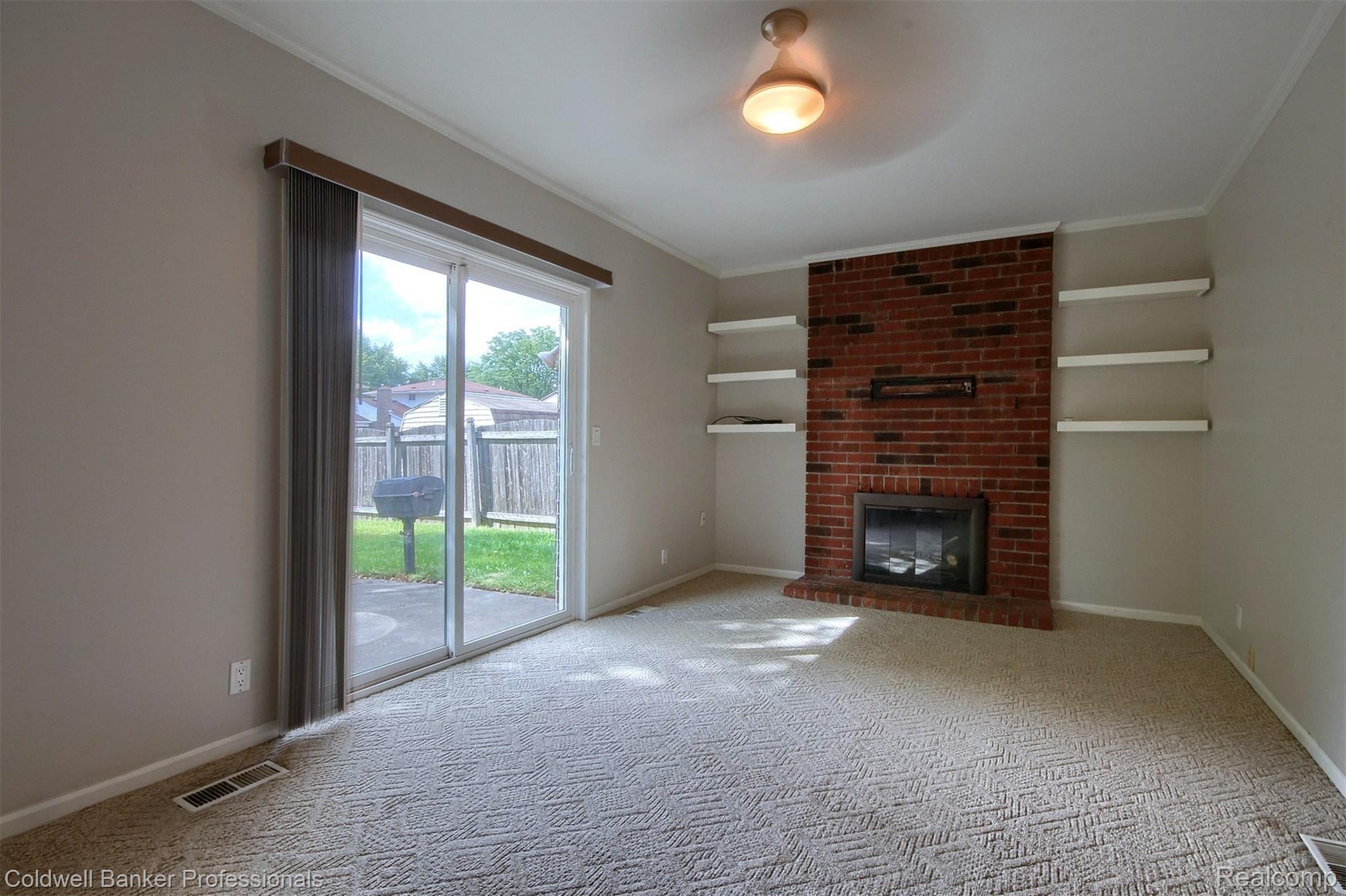6151 Raintree Drive Canton, MI 48187 - Photo 17 of 24 Family room with gas fireplace and doorwall to rear patio