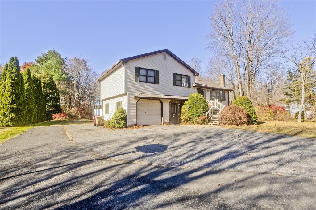 425 Miller Street Ludlow, MA 01056 - Photo 4 of 40 a front view of a house with a yard and garage