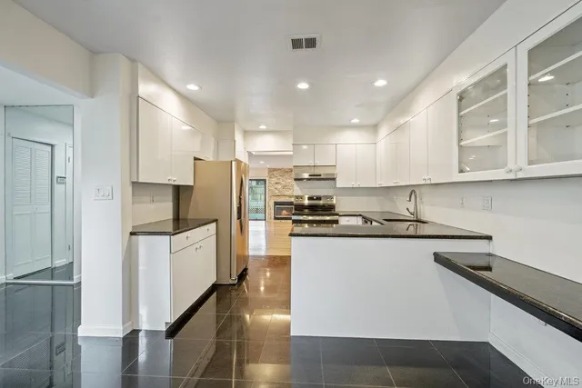 a kitchen with kitchen island a sink stainless steel appliances and cabinets