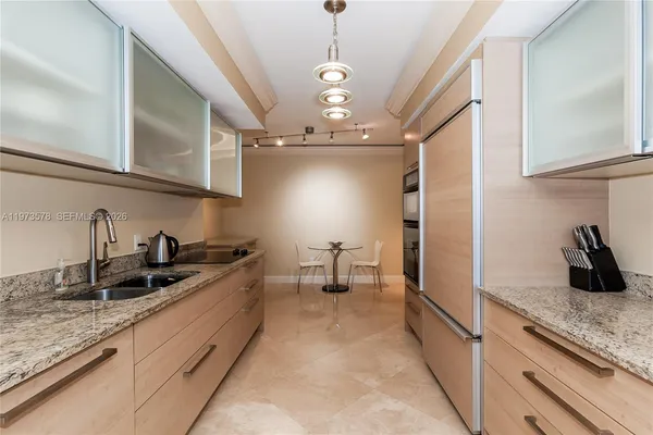a kitchen with stainless steel appliances granite countertop a sink refrigerator and cabinets