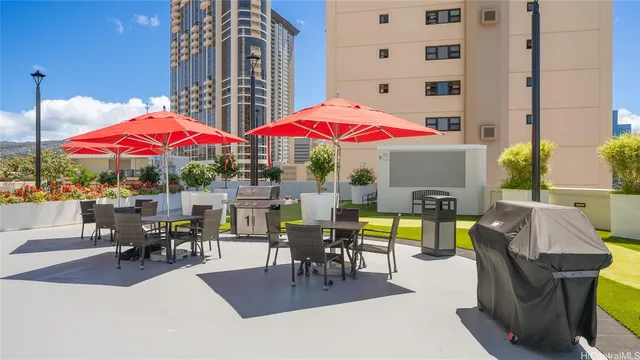 a view of a patio with a table and chairs under an umbrella with a fire pit