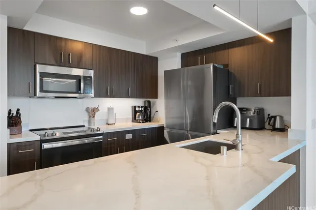 a kitchen with stainless steel appliances wooden cabinets a sink and a stove