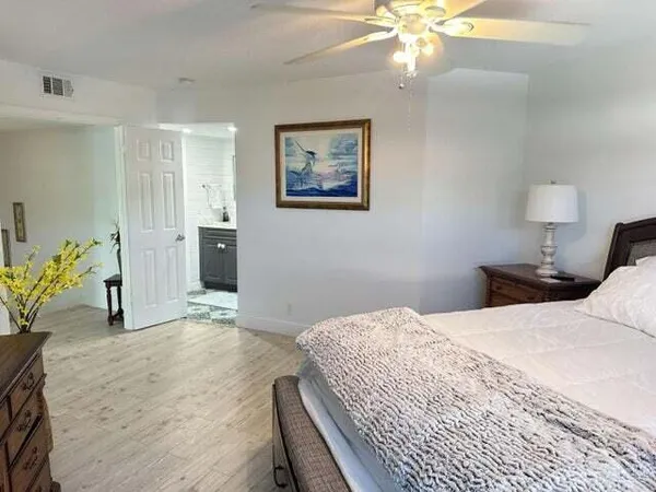 a bedroom with a large bed and a chandelier