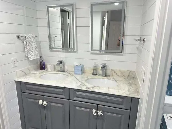 a bathroom with a granite countertop sink and a mirror