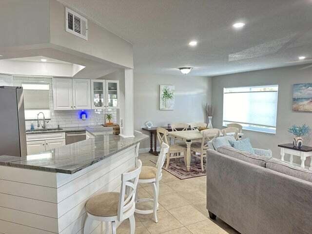 237 Seabreeze Circle Jupiter, FL 33477 - Photo 8 of 20 a kitchen with stainless steel appliances kitchen island granite countertop a sink and cabinets