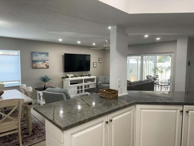 237 Seabreeze Circle Jupiter, FL 33477 - Photo 9 of 20 a kitchen with granite countertop a sink and a stove top oven with wooden floor