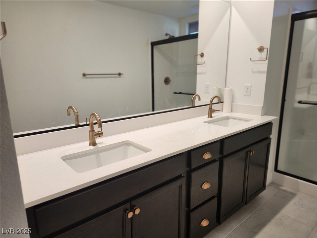 3197 Bertonico Street Henderson, NV 89044 - Photo 9 of 30 Bathroom with double vanity, a shower stall, and light tile patterned floors
