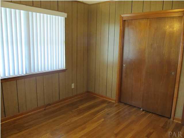 6084 St Alban Road Pensacola, FL 32503 - Photo 11 of 18 Front Bedroom with hardwood flooring, sliding closet doors, and large window for natural lighting!