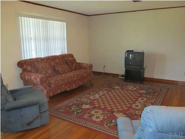 6084 St Alban Road Pensacola, FL 32503 - Photo 3 of 18 The living room boasts beautiful original hardwood flooring, crown molding, a large picture window, and is very spacious!
