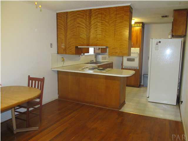 6084 St Alban Road Pensacola, FL 32503 - Photo 5 of 18 The kitchen/dining area has a breakfast bar and hardwood flooring.