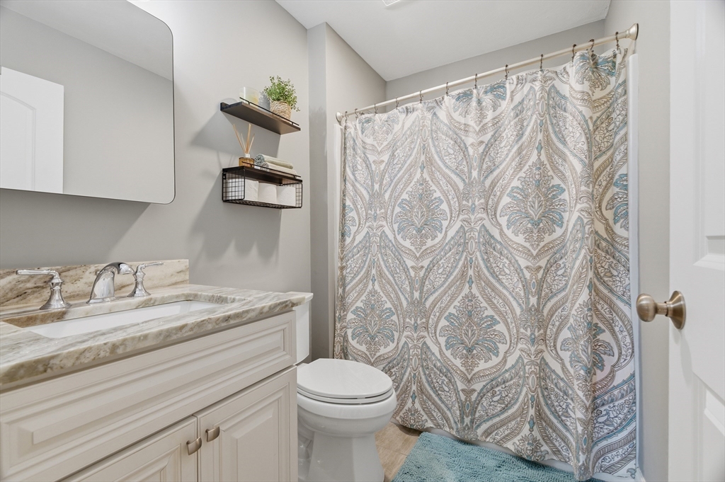 19 Progress Avenue Dudley, MA 01571 - Photo 20 of 42 a bathroom with a granite countertop sink and a toilet