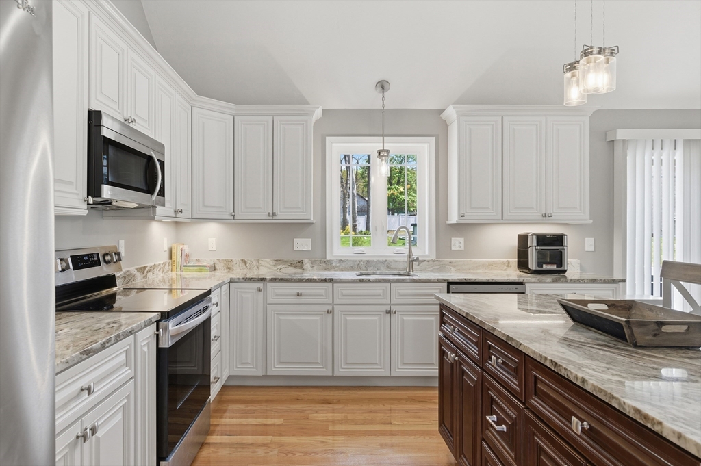 19 Progress Avenue Dudley, MA 01571 - Photo 3 of 42 a kitchen with granite countertop a sink stainless steel appliances and white cabinets