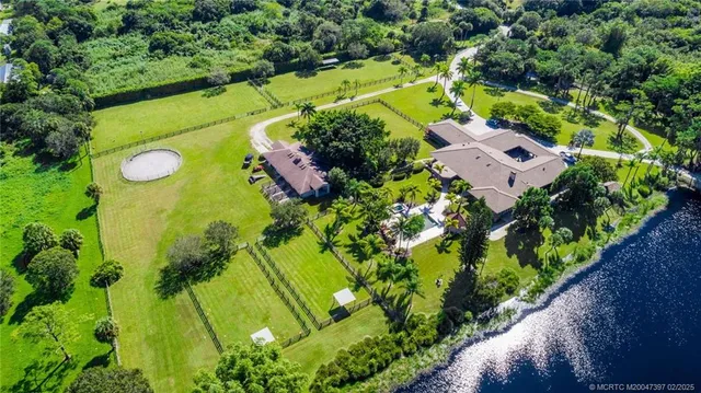 a bathroom with a granite countertop sink a toilet a mirror and shower