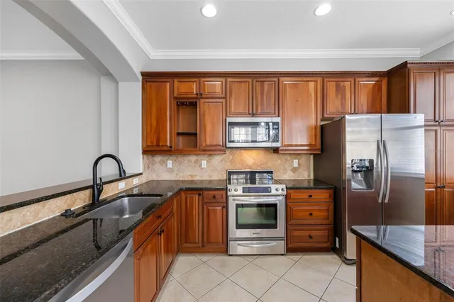 a kitchen with stainless steel appliances granite countertop a refrigerator and a sink