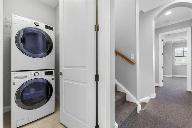 an empty room with chandelier fan and windows