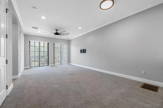 an empty room with windows and fan
