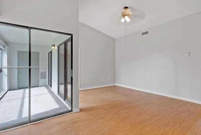 a view of a hallway with wooden floor and cabinet
