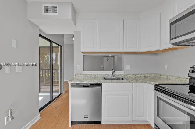 a kitchen with stainless steel appliances granite countertop a sink stove and cabinets