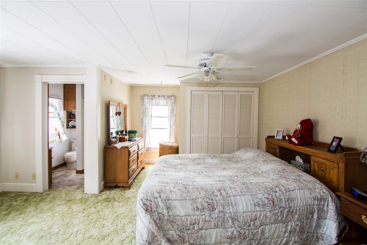 5565 Briery Branch Road Dayton, VA 22821 - Photo 9 of 26 a spacious bedroom with a bed and a chandelier