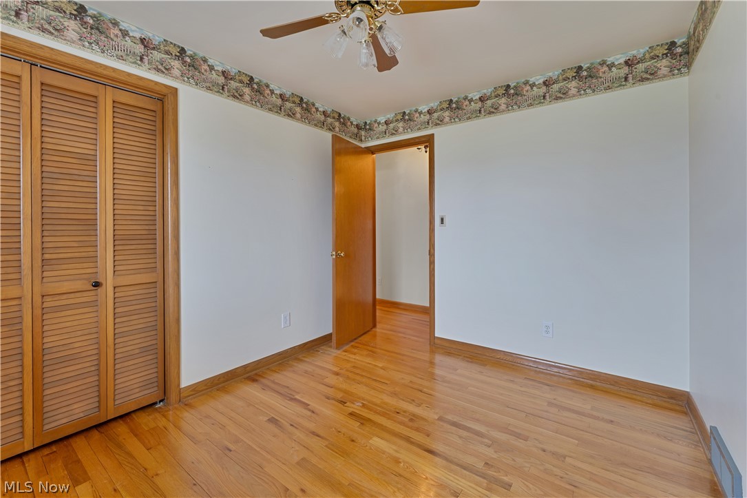 6599 Struthers Road Youngstown, OH 44514 - Photo 25 of 29 Unfurnished bedroom with light wood finished floors, a closet, and a ceiling fan