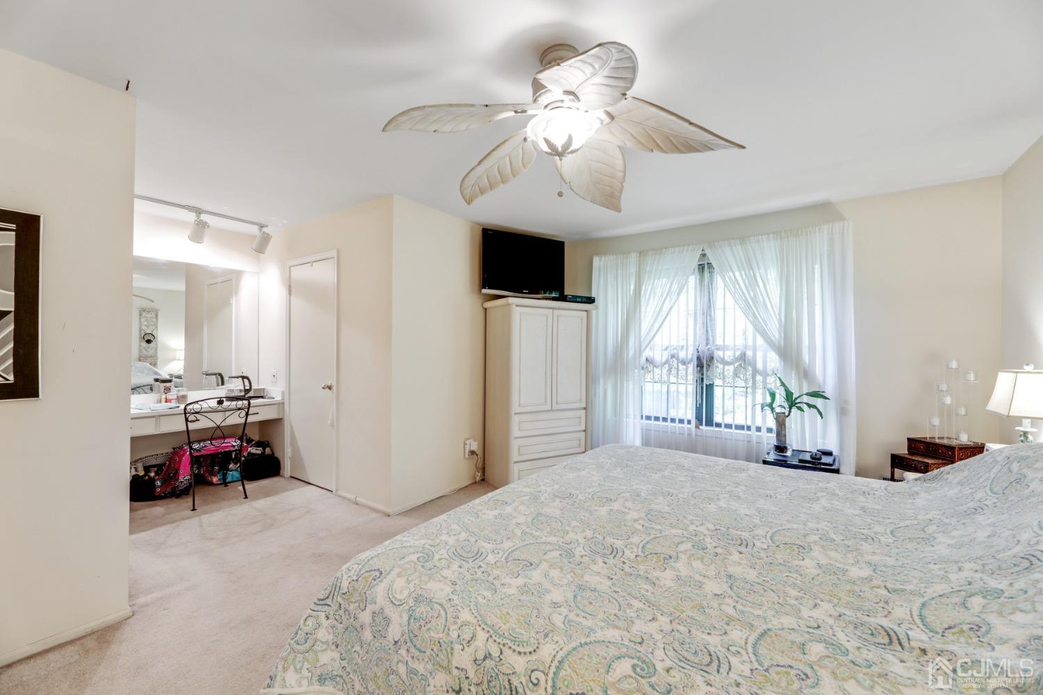 81 Pheasant Run Edison, NJ 08820 - Photo 13 of 24 a spacious bedroom with a bed and a chandelier