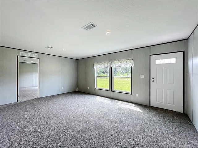 an empty room with windows and closet