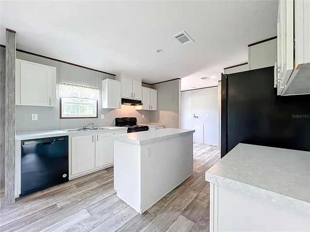 a kitchen with a sink a stove and a window