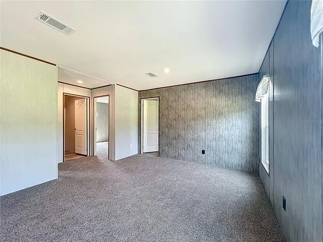 a view of a big room with closet and windows