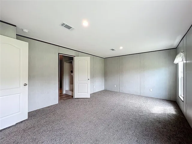 an empty room with windows and closet
