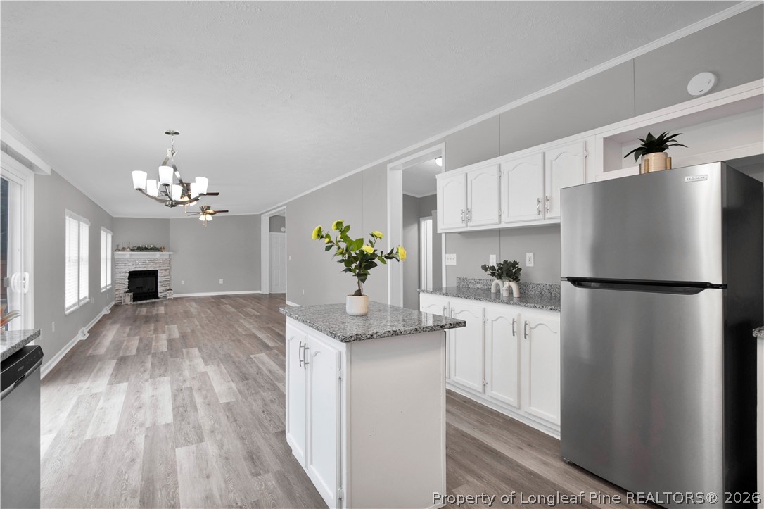 143 South Cherry St Extension Pinebluff, NC 28373 - Photo 12 of 25 a kitchen with stainless steel appliances granite countertop a refrigerator a sink dishwasher a stove and white cabinets with wooden floor