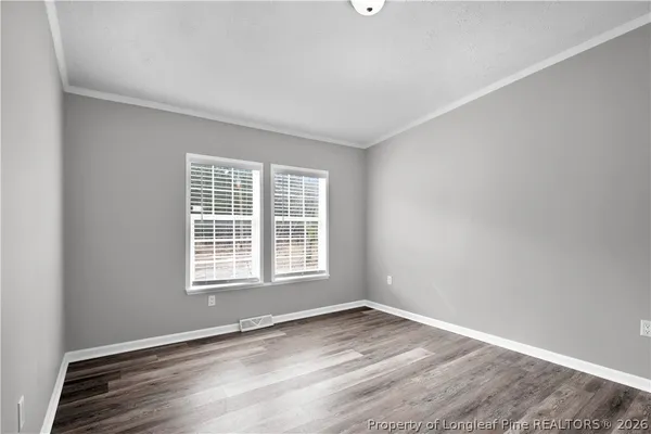 a view of an empty room with wooden floor