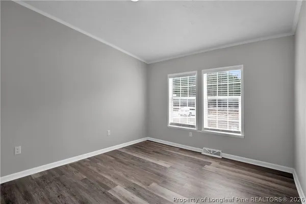 a view of an empty room with wooden floor