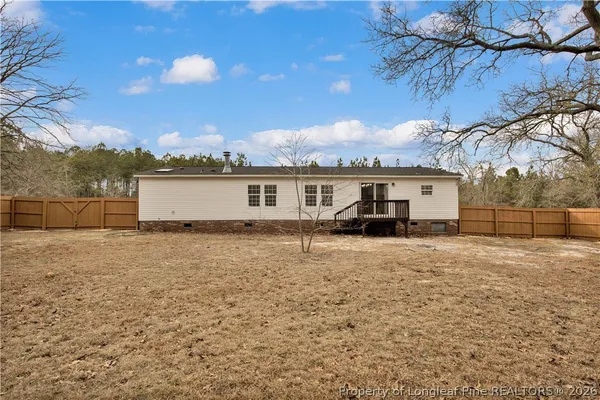 a white house that has a tree in front of it