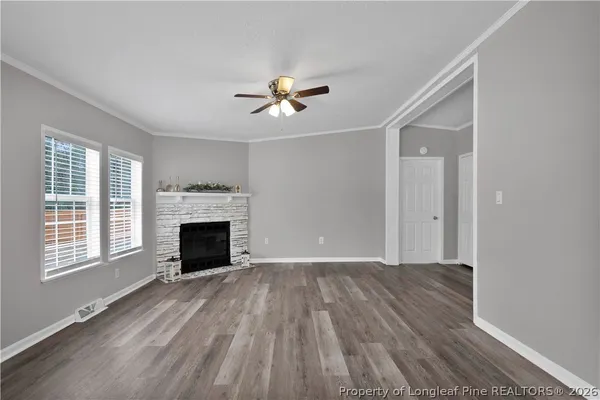 a view of an empty room with a fireplace and a window