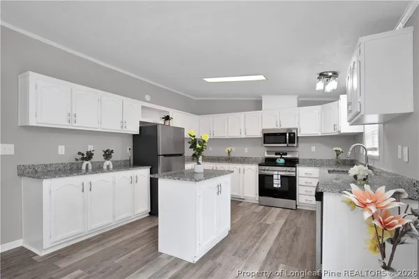 a kitchen with granite countertop a sink stove and cabinets