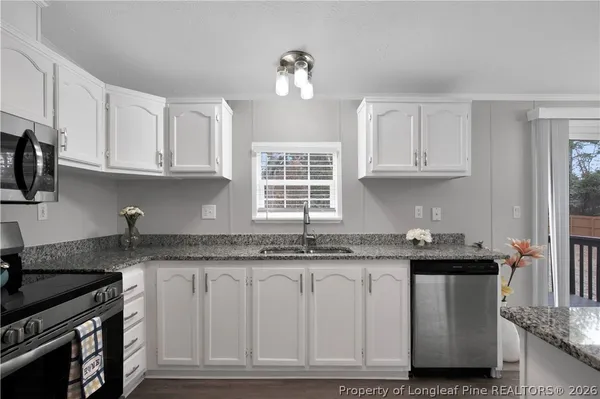 a kitchen with granite countertop a stove and cabinets