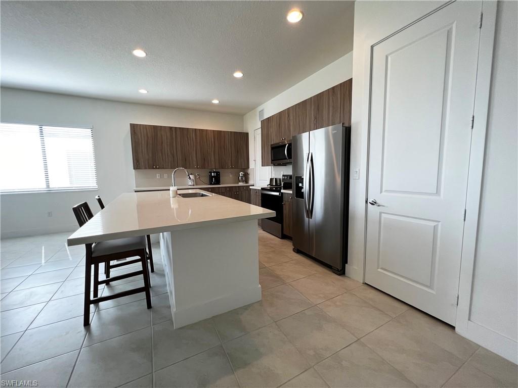 5015 Frattina St Avenue Immokalee, FL 34142 - Photo 2 of 23 a kitchen with stainless steel appliances a refrigerator and a stove top oven