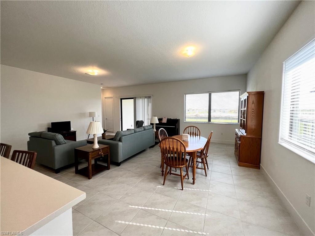 5015 Frattina St Avenue Immokalee, FL 34142 - Photo 5 of 23 a living room with furniture a large window and a table