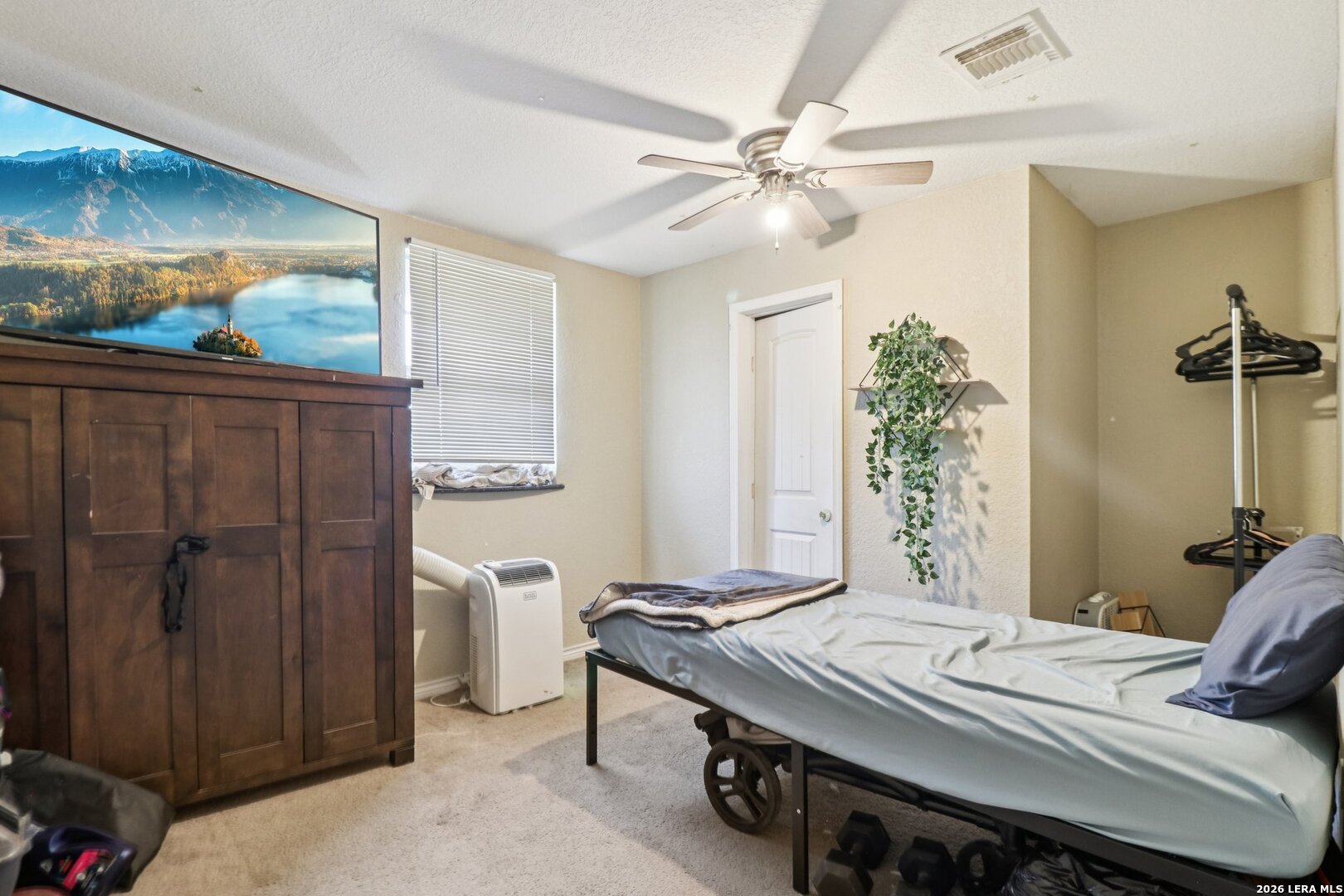 215-213 Coughran Road Pleasanton, TX 78064 - Photo 11 of 13 a bedroom with a bed and a chandelier
