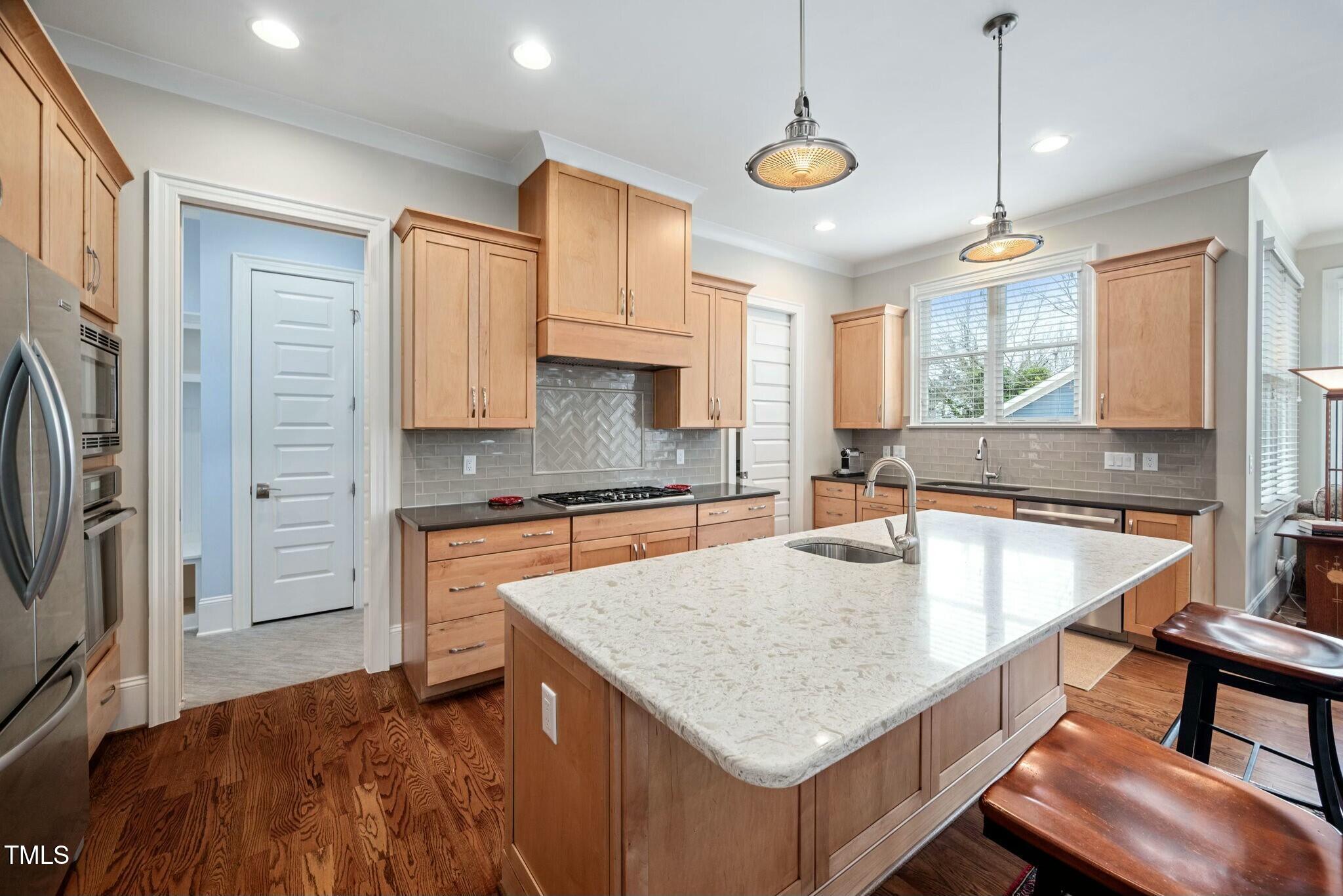 519 Peebles Street Raleigh, NC 27608 - Photo 15 of 43 a kitchen with stainless steel appliances granite countertop a sink a stove and a refrigerator