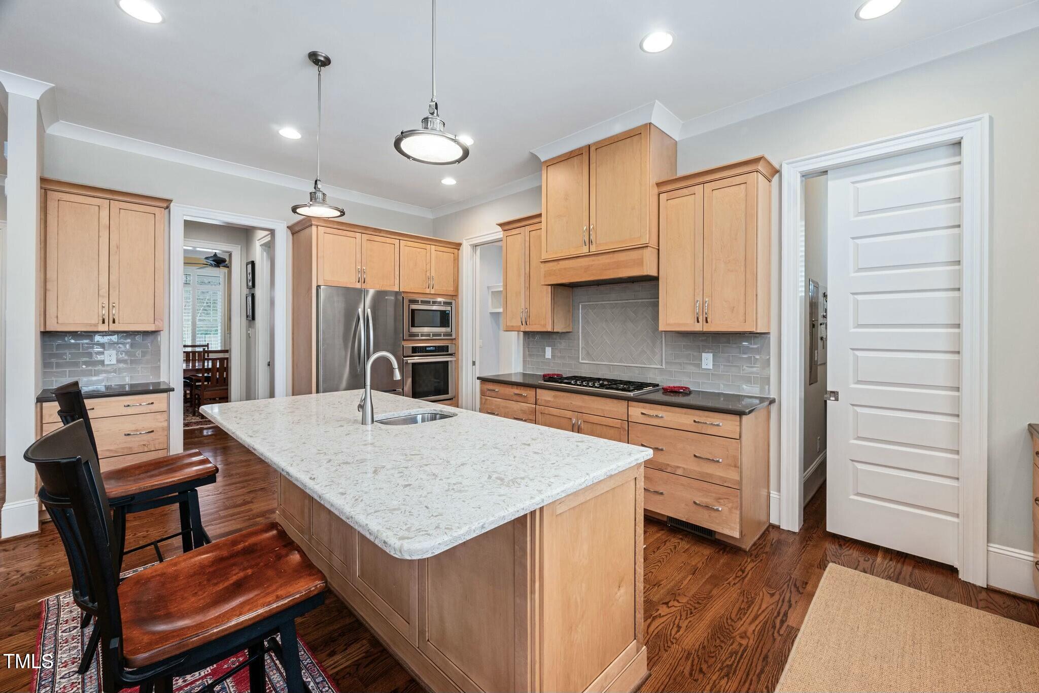 519 Peebles Street Raleigh, NC 27608 - Photo 17 of 43 a kitchen that has a table chairs in it wooden floors and white cabinets