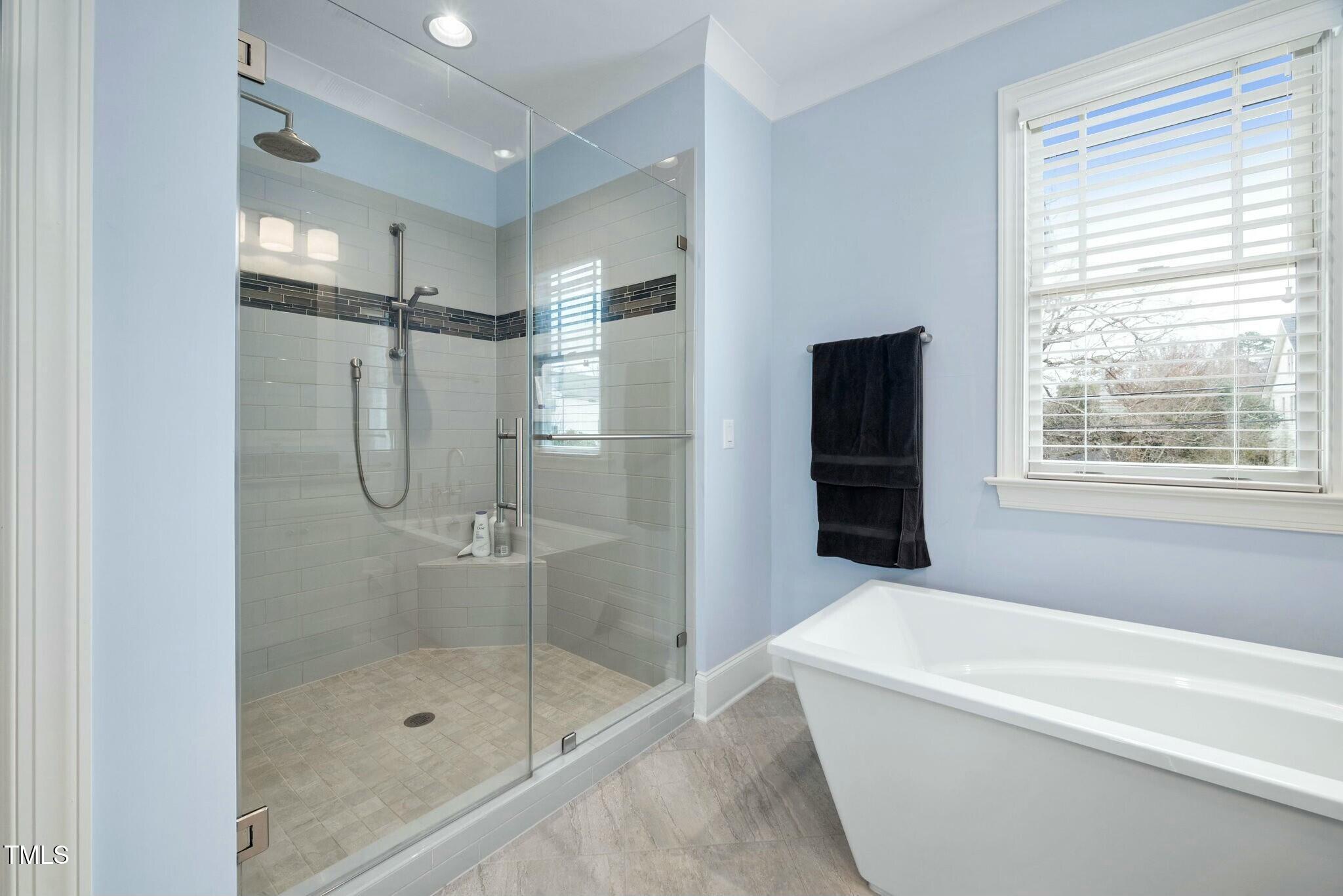 519 Peebles Street Raleigh, NC 27608 - Photo 21 of 43 a bathroom with a bathtub and a shower